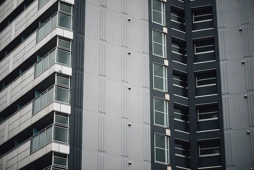 Fachada de um edifício residencial moderno, com varandas e janelas alinhadas.